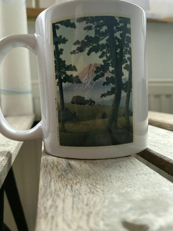 Weiße Tasse mit einem japanischen Holzschnitt: Berg Fuji hinter Kiefern